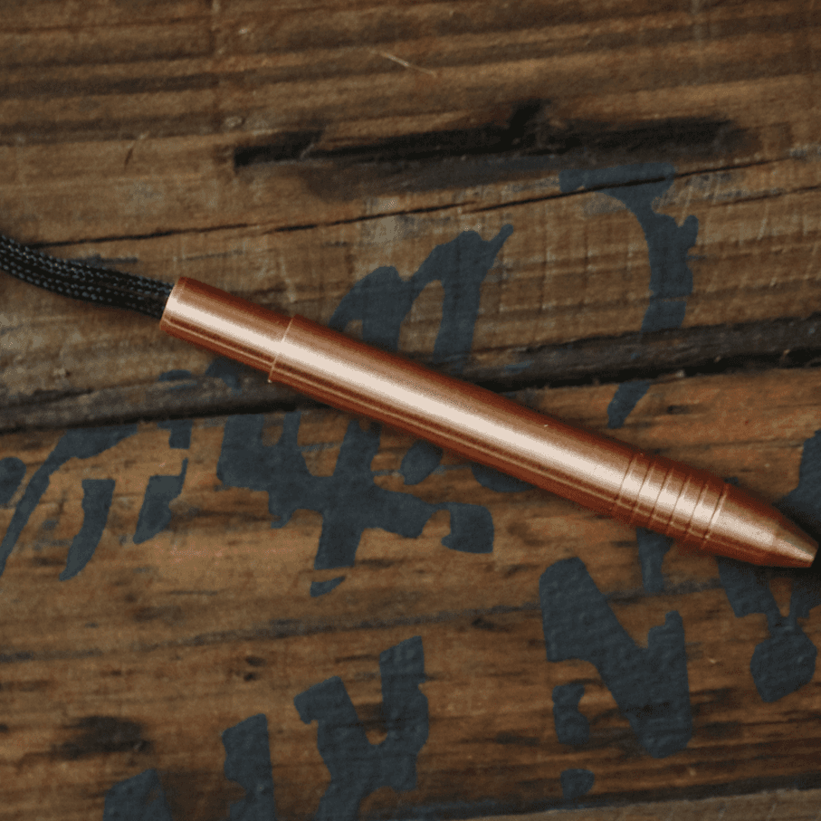 Big Idea Design LLC EDC titanium mini pen in copper finish with attached lanyard on wooden background