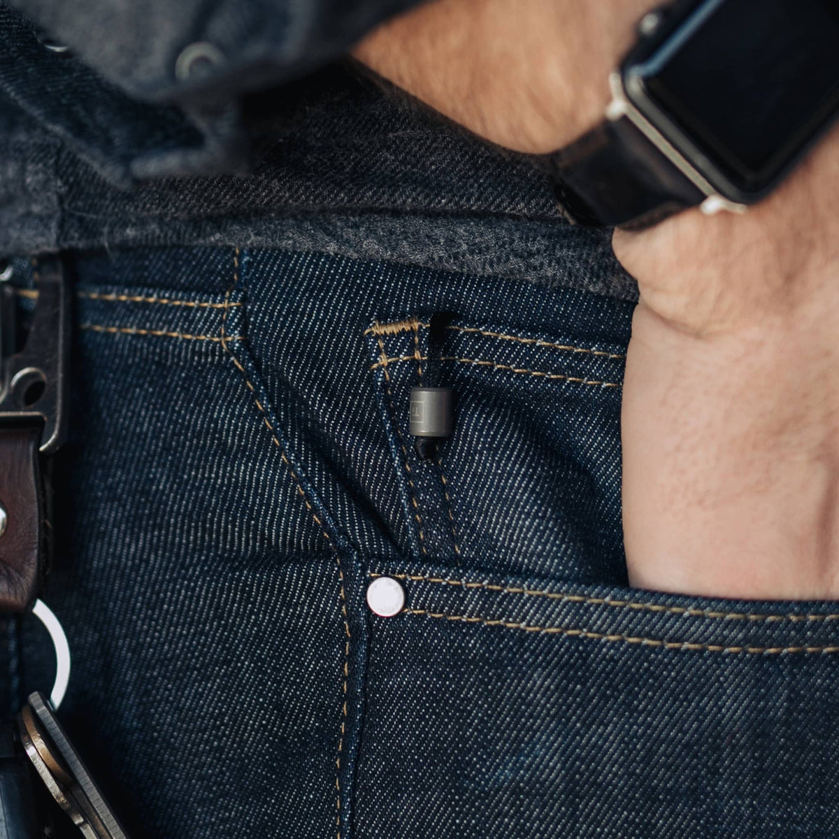 EDC titanium mini pen clipped to the small pocket of dark blue denim jeans