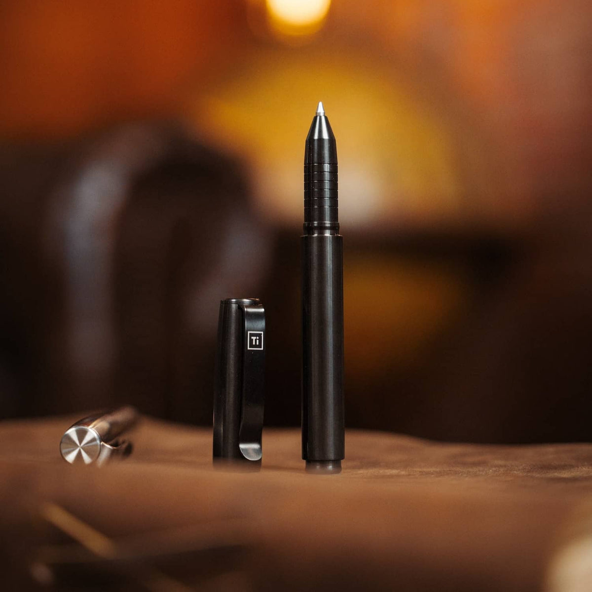 Black titanium capped pen by BIG IDEA DESIGN LLC with sleek modern design on wooden surface