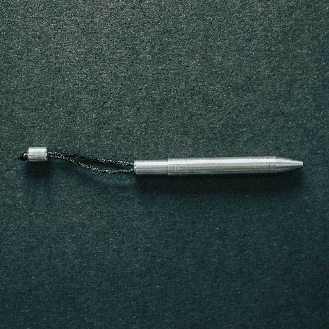 Big Idea Design LLC EDC titanium mini pen with sleek metallic finish and attached lanyard