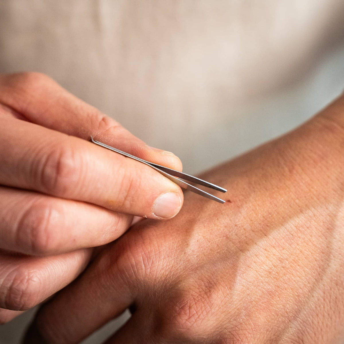 Knafs multi tool pen in stainless steel finish held in hand for precise tasks