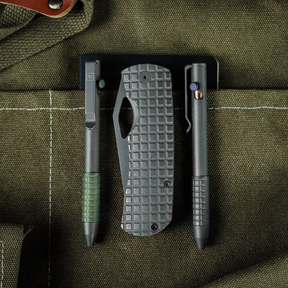 McNeese Pen in gray with ergonomic grip alongside tactical knife and accessories