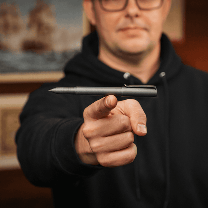 Person holding a sleek titanium capped pen from BIG IDEA DESIGN LLC with a black matte finish